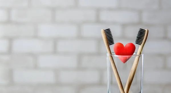 Twee Tandenborstels Het Glas Rood Hart Bakstenen Muurachtergrond Liefde Valentijnsdag — Stockfoto