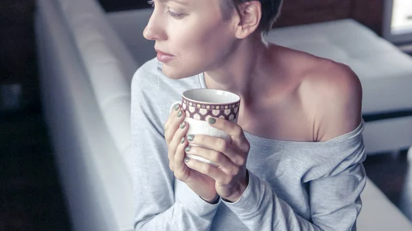 Młoda Kobieta Pijąca Kawę Lub Herbatę Porannym Światłem Białej Kuchni — Zdjęcie stockowe