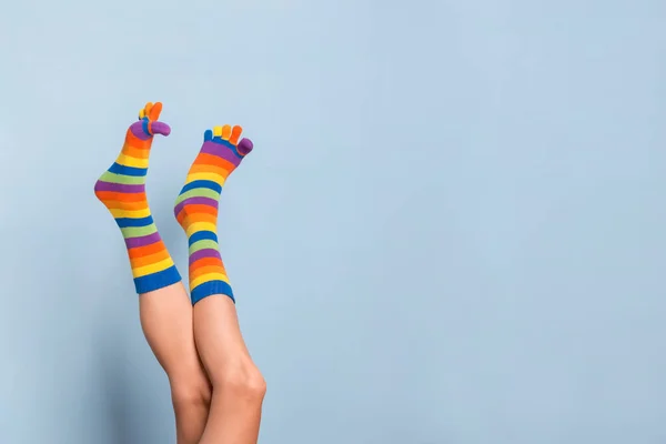 Αστεία Παιχνιδιάρικα Πόδια Γυναίκας Φορώντας Πολύχρωμες Κάλτσες Πάνω Από Μπλε — Φωτογραφία Αρχείου