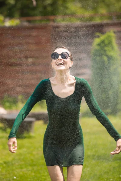 在夏日雨女之下跳舞 美丽的女人 戴着太阳镜 穿着艳丽的夏景中的绿色衣服 — 图库照片
