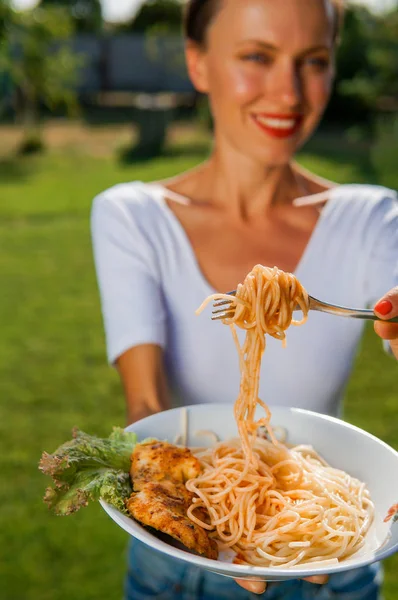 Young brunette woman eating spaghetti