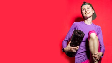 Kırmızı arka planda izole edilmiş köpük silindirli çekici ve formda bir kadın görüntüsü.