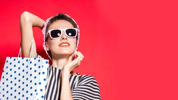 Fröhliche Shoppingfrau Mit Einkaufstaschen Vor Knallrotem Hintergrund Mit Hut Und — Stockfoto
