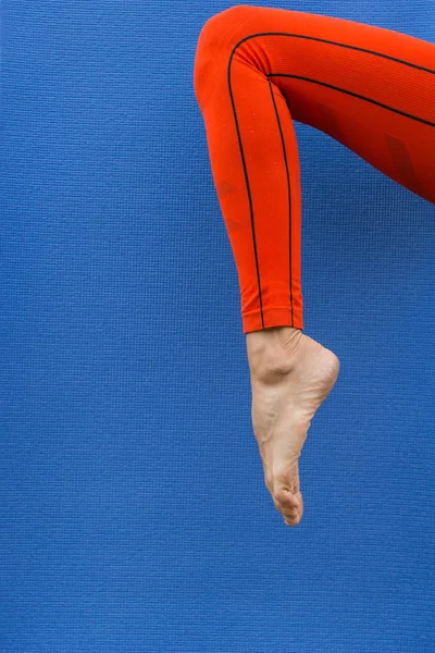 Blue yoga mat texture and slim woman leg, minimal style, copy space