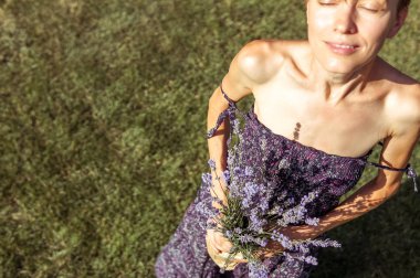 Elinde lavanta çiçekleri olan güzel bir kadın.