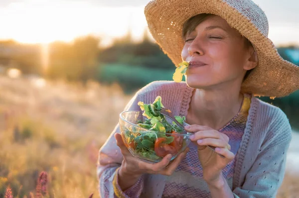 Schöne Kaukasische Frau Isst Salat Über Grünen Natürlichen Hintergrund — Stockfoto