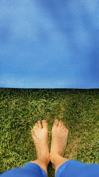 Female Legs Blue Half Rolled Yoga Mat Green Grass Background — Stock Photo, Image
