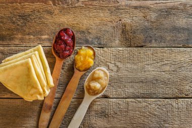 Ev yapımı yulaf krepleri, ahşap kaşıklı lezzetli, ince krepler ve farklı reçeller.