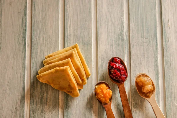 自制燕麦奶油 薄薄的煎饼 配以木制勺子和不同的果酱 — 图库照片
