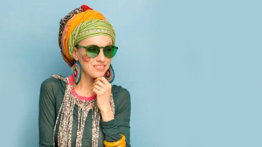 Kafasında türbanı, moda küpeleri ve bileziği olan güzel bir kadın. Afrika tarzı kadın konsepti