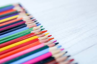 Ahşap arka planda izole edilmiş çok renkli kalemler 