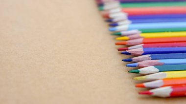Kağıt kahverengi arkaplanda renkli kalemler