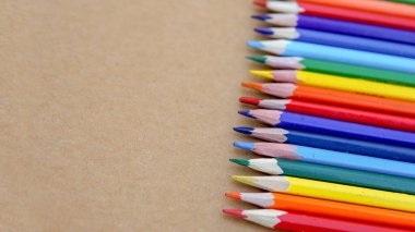 Kahverengi kağıt arkaplanda renkli kalemler