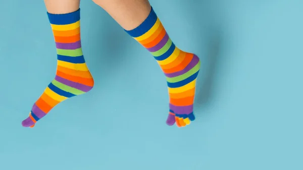 Mavi Arka Planda Renkli Çoraplar Giyen Neşeli Kadın Bacakları — Stok fotoğraf