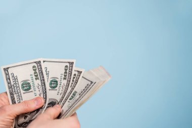  Mavi arka planda bir el içinde para
