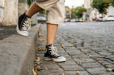 Madrid, İspanya... 23 Eylül 2019: Spor ayakkabılı güzel, uzun bacaklı bir kadın yazın şehvetli moda hipster spor tarzında dışarıda poz veriyor.