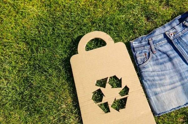 Symbol Recyklingu Tkaninie Jeansowej Nad Zieloną Trawą Nowa Spódnica Byłego — Zdjęcie stockowe