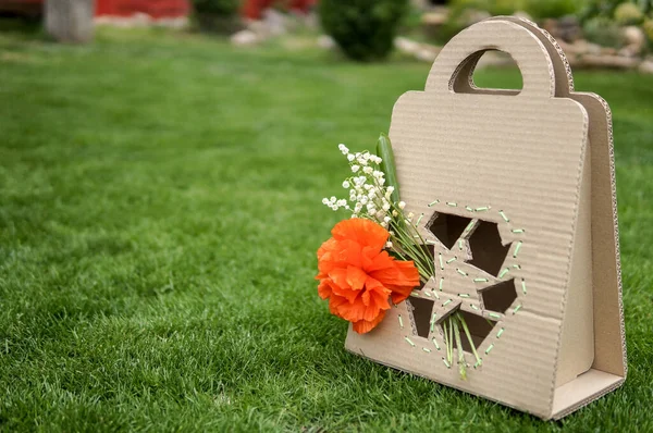 Papiertüte Mit Recyclingschild Und Blumen Über Grünem Gras Hintergrund — Stockfoto