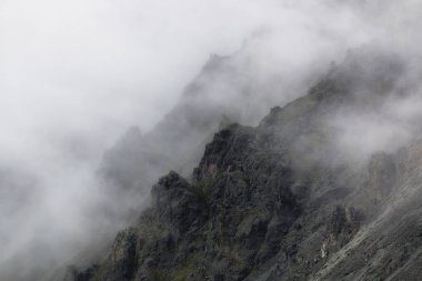 engebeli dağ zirveleri sis içinde