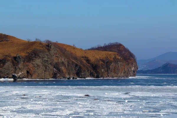 冬天结冰的海面附近有岩石斗篷 — 图库照片