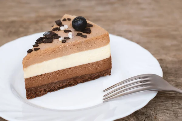 Triple chocolate mousse cake on white plate. — Stock Photo, Image