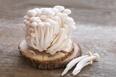 Enoki mushrooms on wooden background, close up. clipart