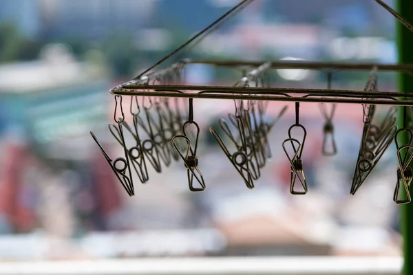 Arka planda tel ile asılı metal mandallar.
