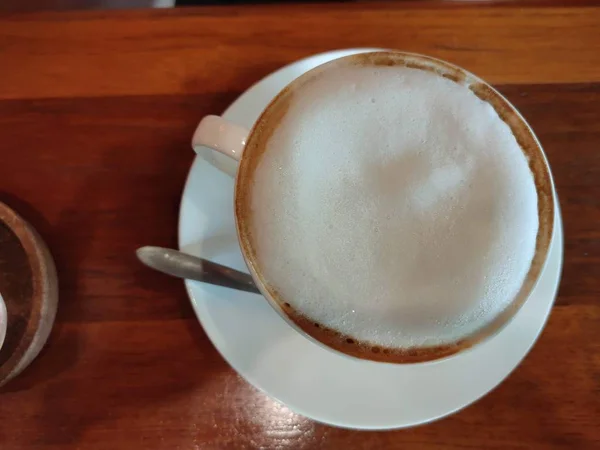 Cappuccino ou latte com espuma espumosa, copo de café azul vista superior closeup isolado no fundo branco. Café e bar, conceito de arte barista . — Fotografia de Stock