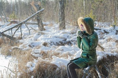 Genç kadın açık havada karlı kış ormanda mola