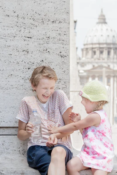 Two siblings having fun with water from plastic bottle in hot summer day — Stock Photo, Image