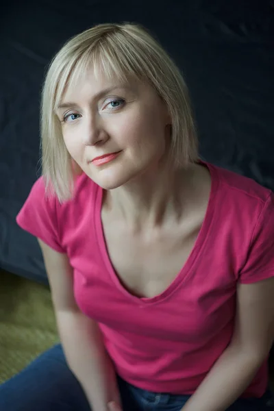 Blonde smiling woman wearing fuchsia color shirt vertical portrait