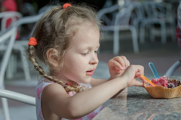 Liten flicka äter hennes italienska wafer glasstrut — Stockfoto