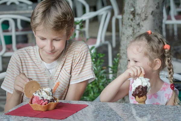 Boy and girl kids enjoying their Italian ice cream in gelateria Stock Picture