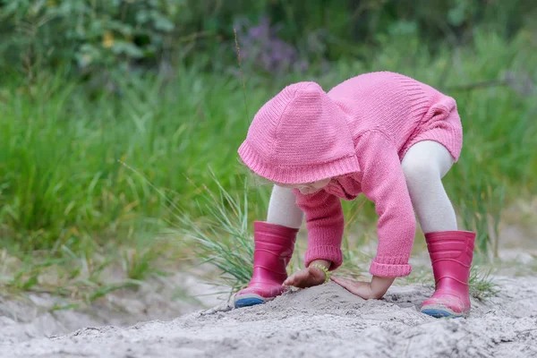 Preschooler girl playing with sand in summer forest — Stock Photo, Image