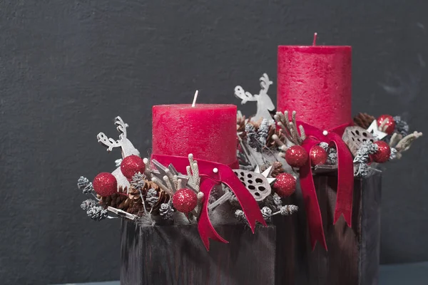 Rote Kerzen und Holz-Rentiere in weihnachtlicher Tischdekoration — Stockfoto