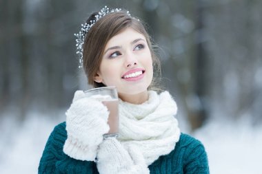 Gülümseyen kız sıcak kakao cam fincan marshmallow ile tutarak