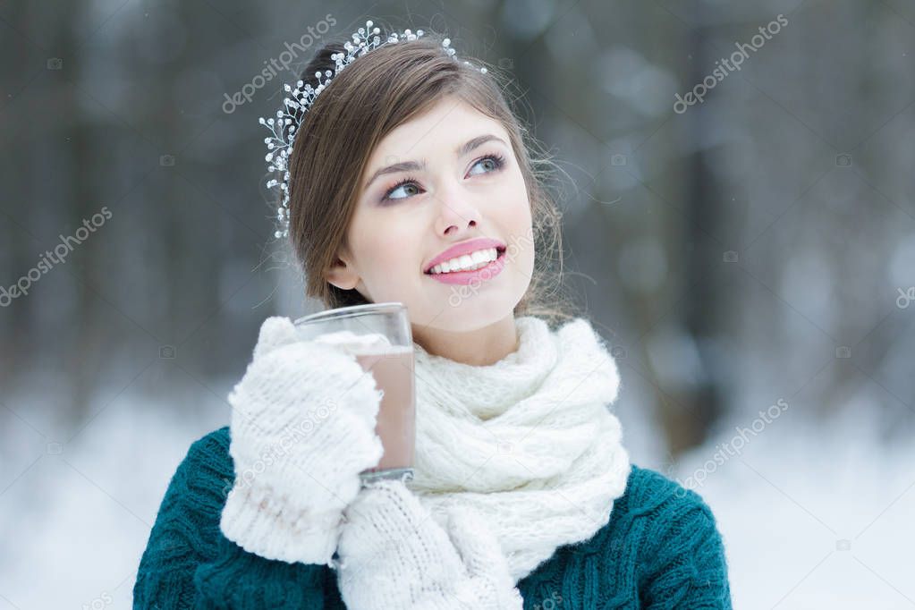 Smiling girl holding hot cocoa glass cup with marshmallows