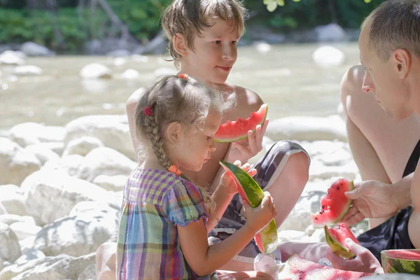 Famiglia di tre spiaggia picnic con anguria — Foto Stock