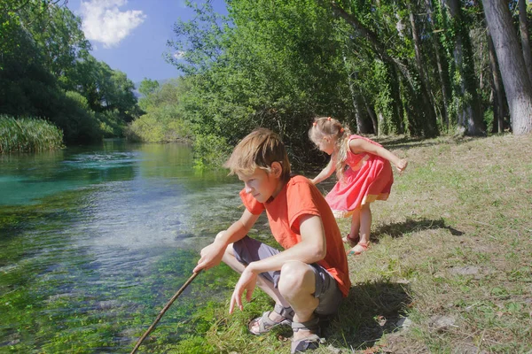 Broers en zussen zomer recreatie activiteit buiten spel op de oever van de Italiaanse Tirino — Stockfoto