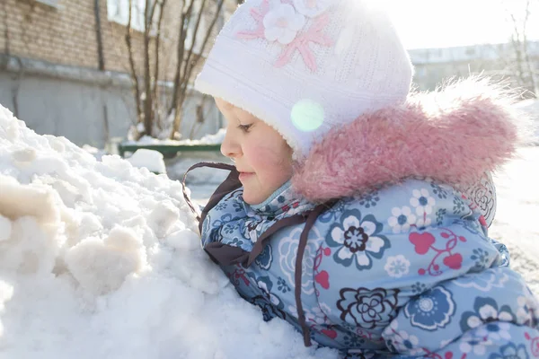 Soleado día de invierno retrato al aire libre de jugar niña en la colina de nieve —  Fotos de Stock