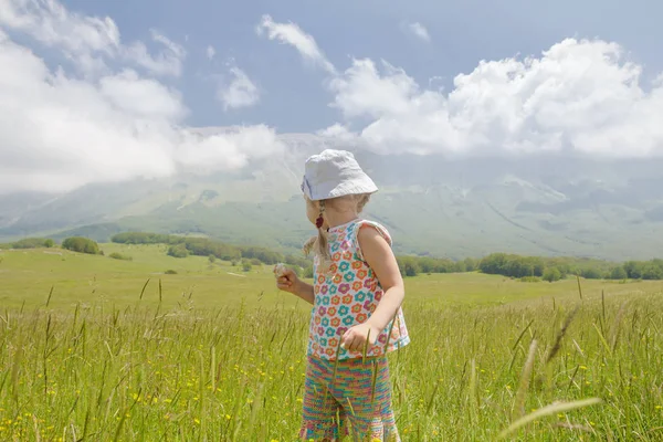 Vue arrière de la petite fille blonde dans les Apennins italiens de la région des Abruzzes regardant les montagnes — Photo