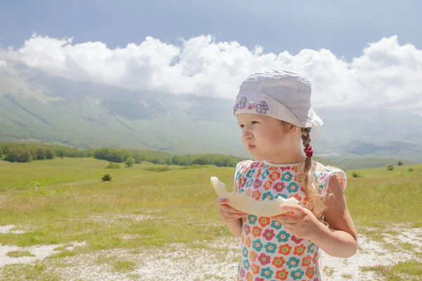 Eating sweet melon slice little girl enjoying Alpine view — Stock Photo, Image