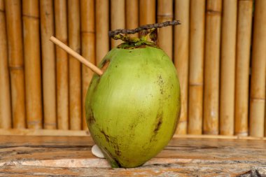 Masada bambu kamışlı taze hindistan cevizi ve kocaman bir odun.