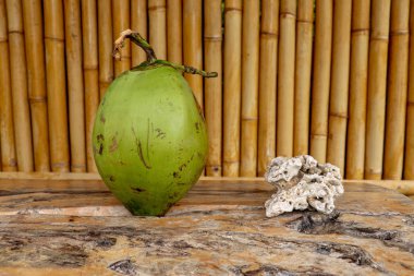 Masada taze hindistan cevizi ve ahşap tahta var. Young Co