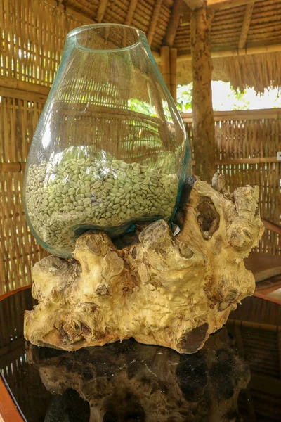 Coffee Arabica beans in a glass ornamental jar placed on an abst