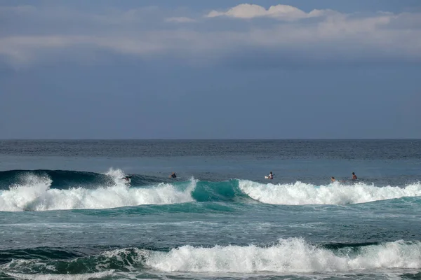 Unge surfere sidder på surfbrætter venter på den rigtige bølge . - Stock-foto