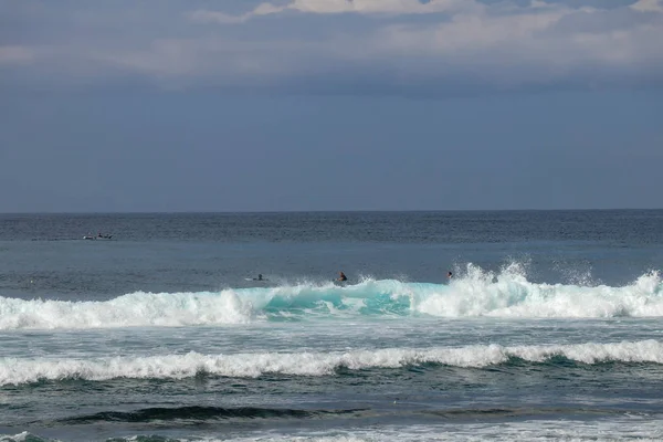 Genç sörfçüler sörf tahtalarında oturmuş doğru dalgayı bekliyorlar.. — Stok fotoğraf