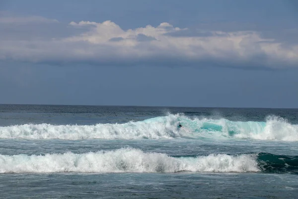 Genç beyaz adam okyanus dalgalarında sörf yapar ve bir sürü spa yapar. — Stok fotoğraf