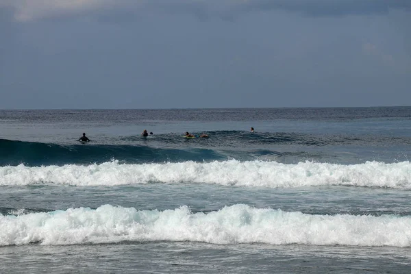 Hombre no identificado en tabla de surf esperando ola en agua azul ba — Foto de Stock