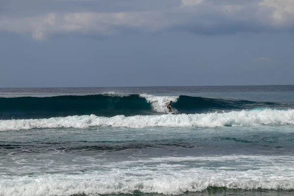 Genç beyaz adam okyanus dalgalarında sörf yapar ve bir sürü spa yapar. — Stok fotoğraf